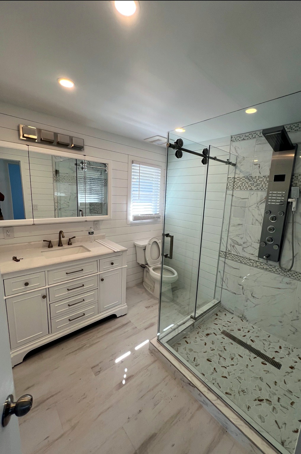 Finished bathroom with vanity, glass shower enclosure, and tile finishes